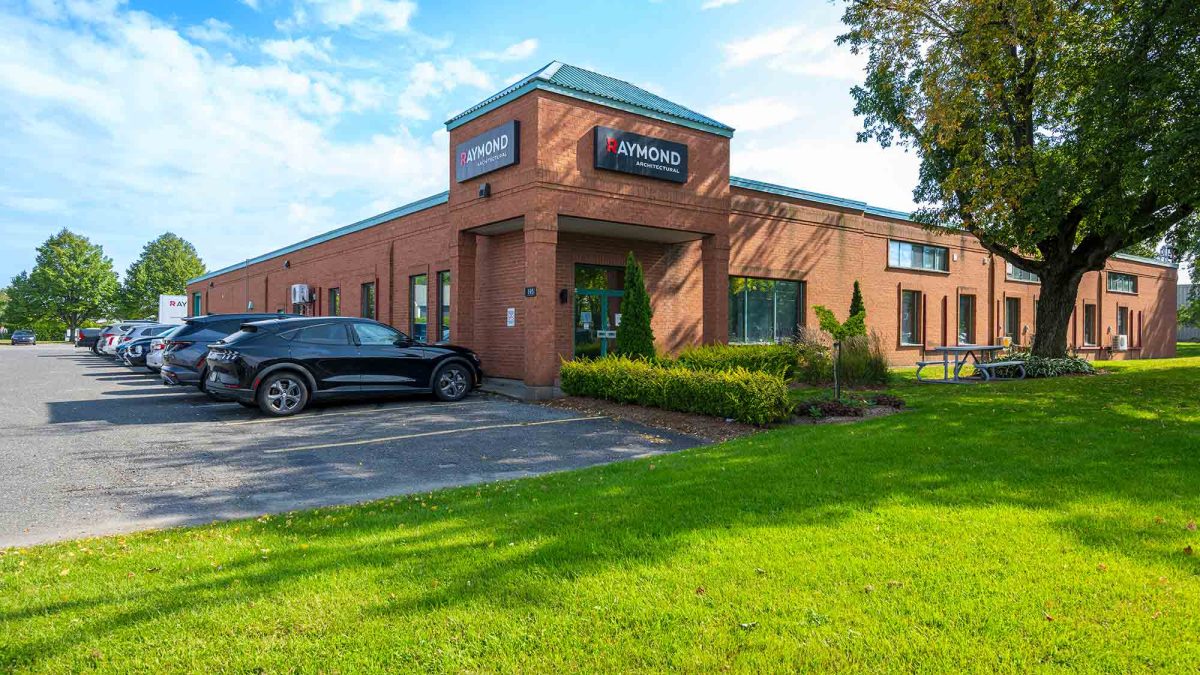 Bâtiment principal de Raymond Architectural avec façade en brique et logo officiel – Québec