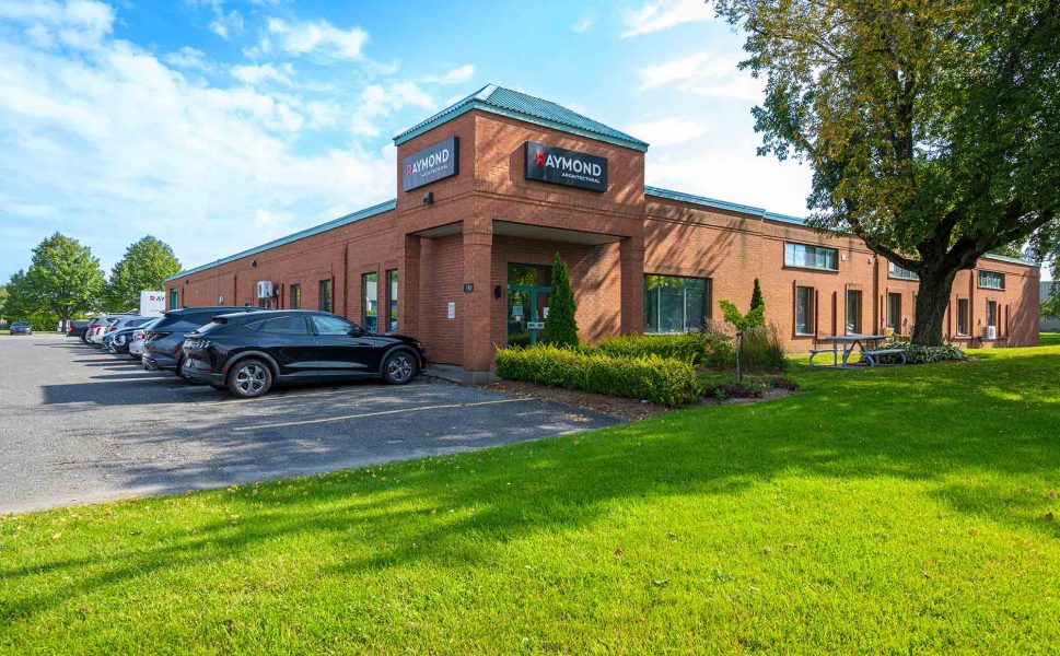 Bâtiment principal de Raymond Architectural avec façade en brique et logo officiel – Québec