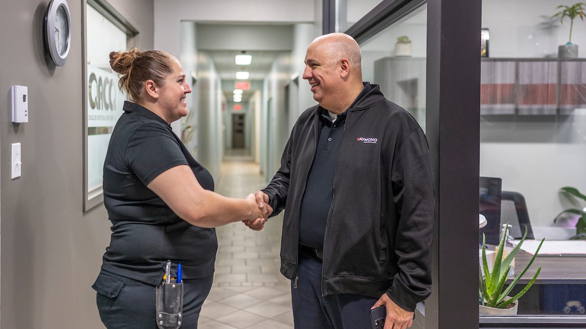 Employés de Raymond Architectural se serrant la main pour conclure une collaboration professionnelle – Raymond Architectural