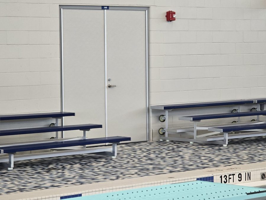 Porte architecturale double en acier installée dans un centre aquatique, près des gradins et du bassin de piscine – Raymond Architectural